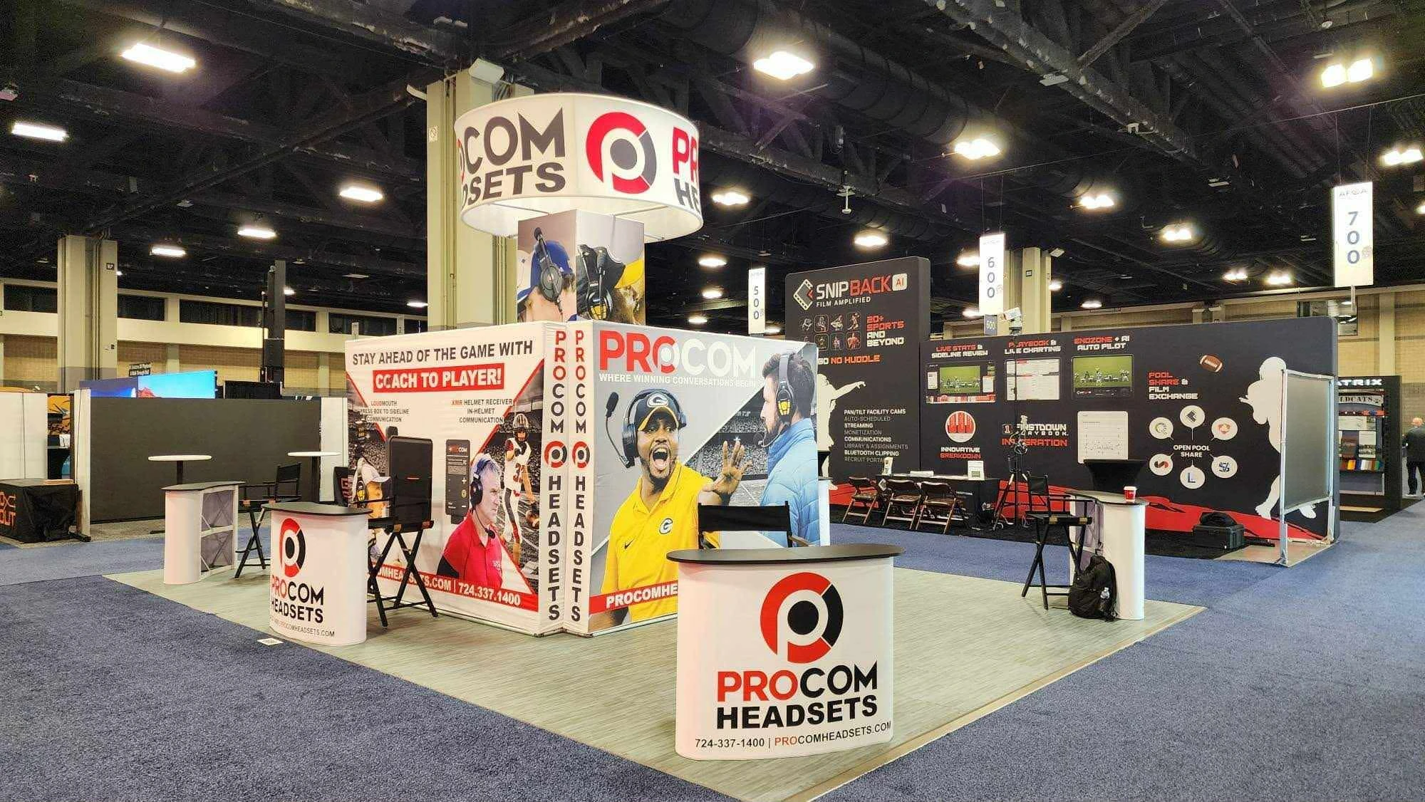 Assembly of a modular trade show tower and circular hanging banner in the warehouse for quality inspection.