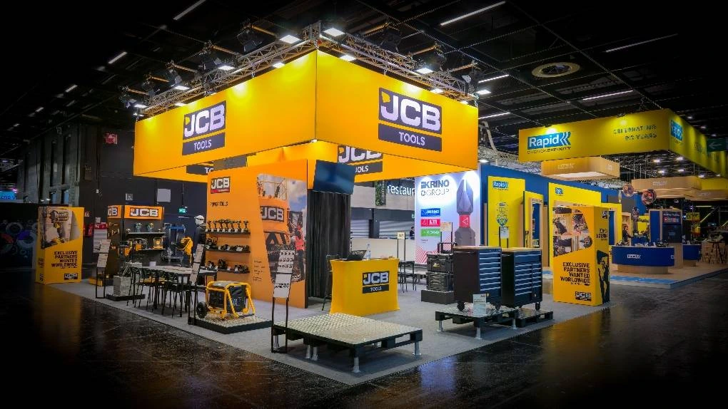 Large exhibition setup with product zones, counters, pillar displays and an overhead hanging sign